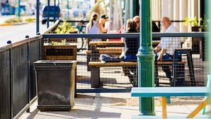 Une scène de rue avec une enseigne indiquant « CENTRE-VILLE DE MESA » et une autre pour « WEST BREWING CO. »