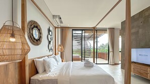 Ein modernes Schlafzimmer mit einem großen Bett, einem Fernseher und einem Balkon mit Blick.