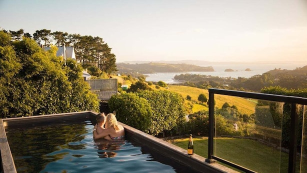 Piscina con vistas a un paisaje, incluyendo árboles y colinas.