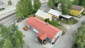 En tågstation med en byggnad som har ett rött tak, en gul byggnad med ett överbyggt område och ett litet förråd.
