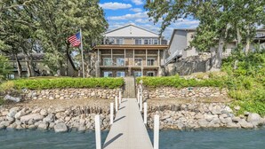 A waterfront property with a dock leading to a house. - Morehead Retreat on 75 ft of East Lake Okoboji (Spirit Lake)