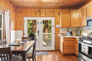 L’intérieur d’une cabine comprend une table à manger, des chaises, une cuisine équipée d’une cuisinière, d’un four à micro-ondes et de placards.