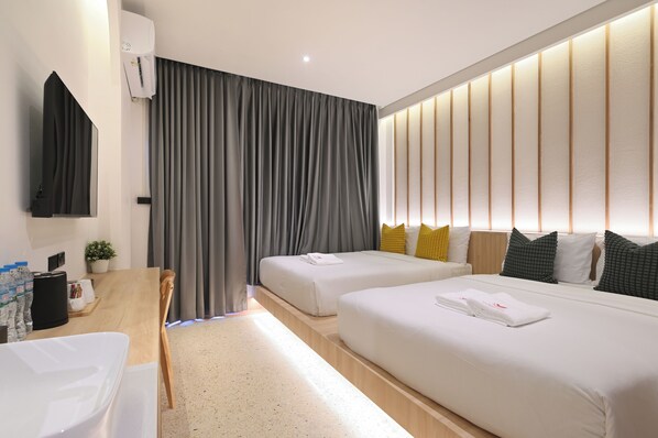 A modern hotel room with two beds, a desk with a chair, a small table, and a large window with curtains. - Tori Primo Hotel (Bangkok)