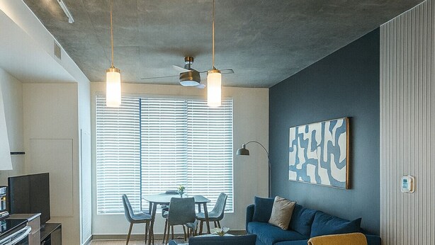 Un saló modern amb un sofà, una taula de centre i una zona de menjador.