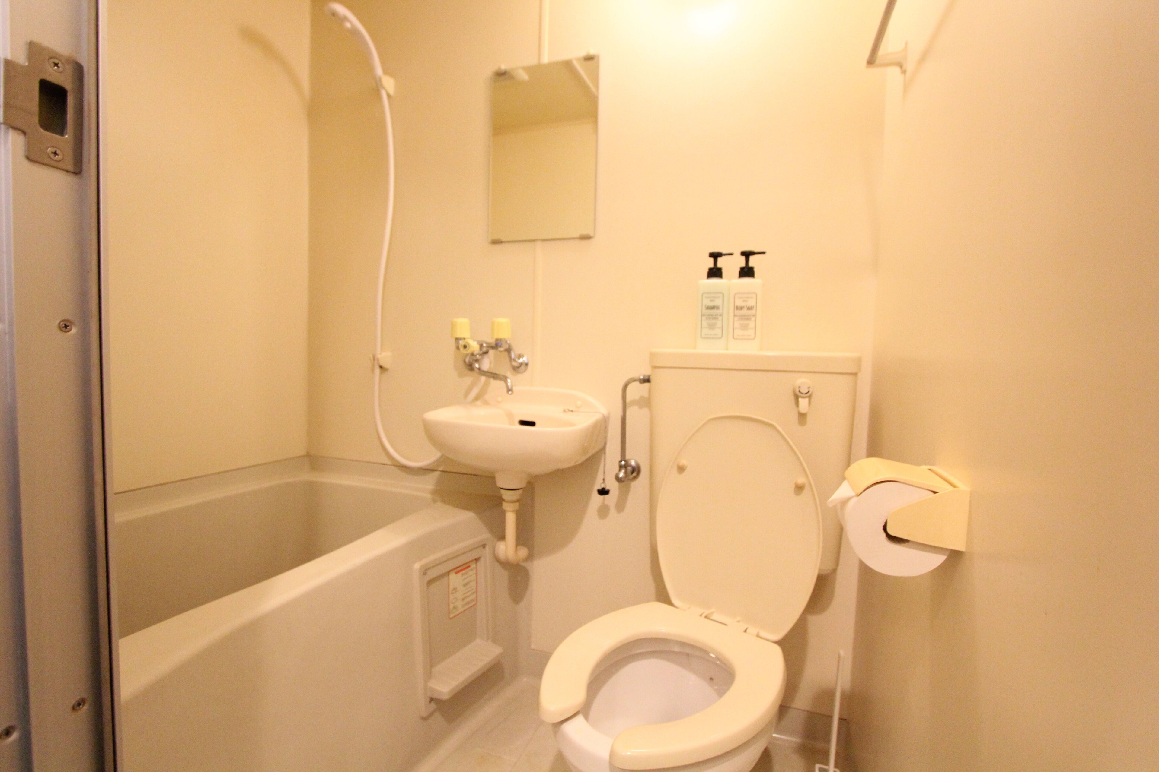 A bathroom with a bathtub, toilet, sink, and a mirror.