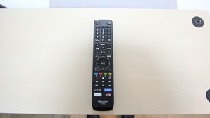 A remote control on a wooden surface.