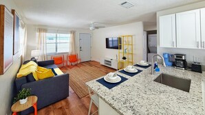 Eine moderne Wohnung mit Wohnzimmer, Küche und Essbereich.