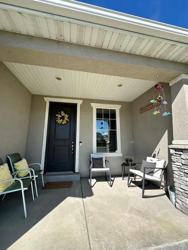 A covered patio with outdoor seating, a door with a wreath, and a sign reading "BARRIENTOS".