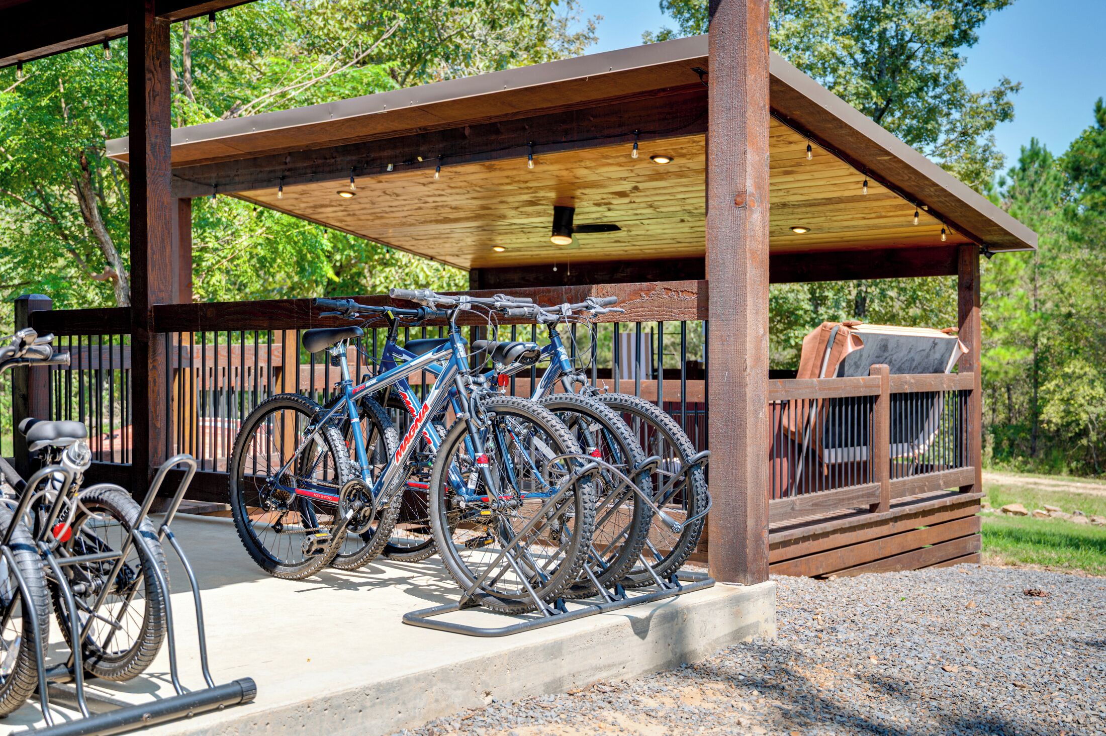 Ett överbyggt område för cykelparkering med plats för flera cyklar och en grill.
