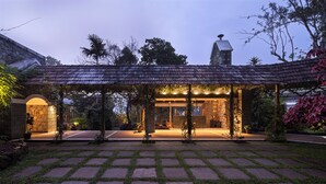 A courtyard with a covered seating area, stone pathway, and surrounding greenery. - SpiceTree Rajakumari (Udumbanchola)