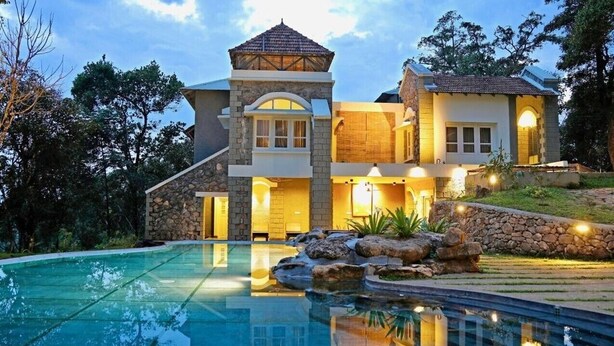 A two-story house with a swimming pool, stone walls, and a gazebo. - SpiceTree Rajakumari (Udumbanchola)