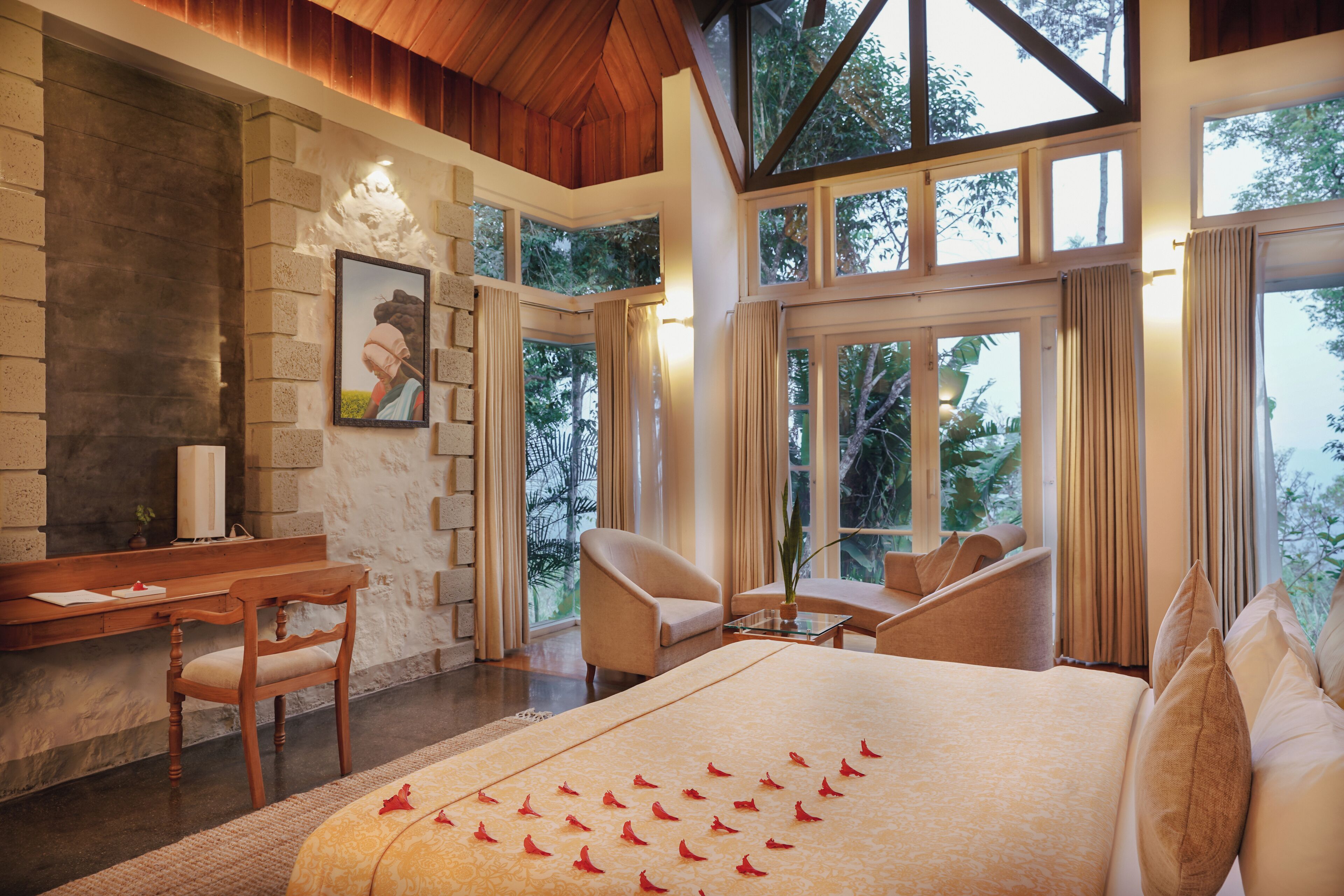 A spacious room with a large bed, a desk, and a comfortable seating area.