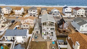 A coastal residential area with houses, a beach, and a clear view of the ocean.