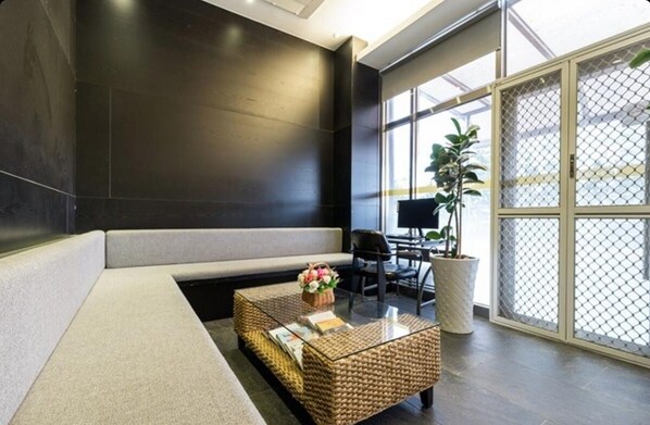 A modern lobby with a seating area, a glass coffee table, and a large window with a view. - Yeosu-si noblehotel (Yeosu)