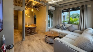 A modern living room with a sofa, dining table, and hanging lights. - Private Villa with Ocean Views | Churaumi & JUNGLIA | BBQ & Fireworks | Sleeps 9 (本部町)