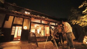 A traditional Japanese building with a wooden exterior and a lit interior, suggesting a restaurant or cultural venue. - Rent a whole house, sauna, and garden (Kaizuka-shi)