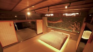 A room with a bed, a large wall mural, and a sliding door.