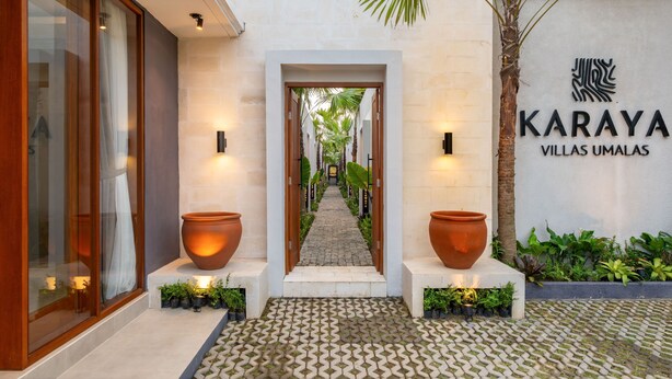 Un chemin menant à un bâtiment sur lequel on peut lire l’inscription suivante : « Karaya Villas Umalas ».