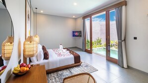 Une chambre moderne avec un lit, une table à manger avec des fruits, un téléviseur et un balcon donnant sur la piscine.