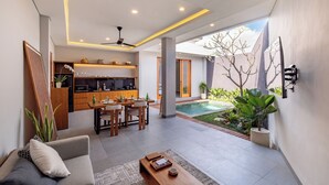 Un espace de vie moderne comprenant une table à manger, un canapé et une vue sur la piscine.