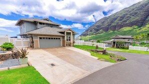 A two-story house with a garage, a driveway, and a well-maintained lawn. - Hawaiian Pakele-Ocean View Estate (Waianae)