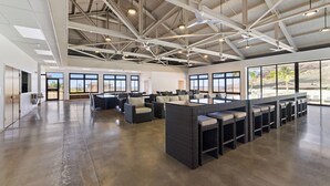 A spacious indoor area with high ceilings, large windows, and seating arrangements. - Hawaiian Pakele-Ocean View Estate (Waianae)