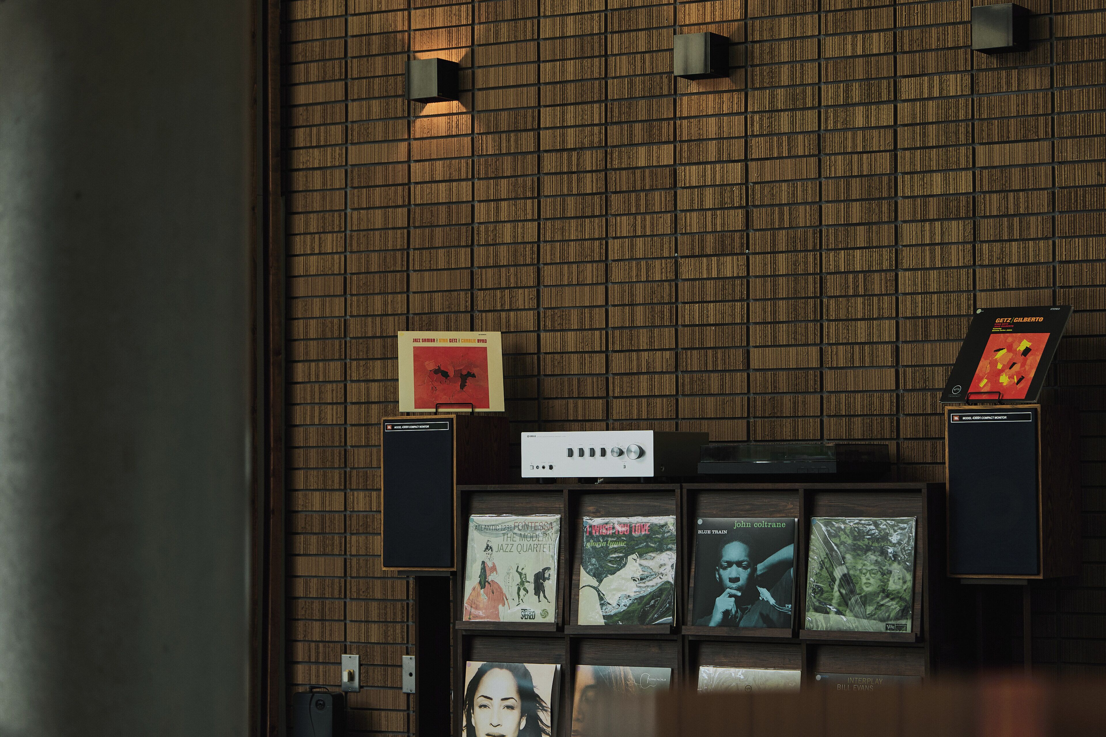 A wall with framed album covers and a sound system.