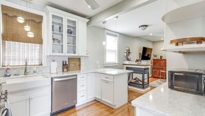 A modern kitchen with white cabinetry, a built-in dishwasher, a microwave, and a wooden island. - Steps to Short Beach: Ocean-View Apt w/ Deck! (Winthrop)