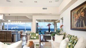 A spacious living area with a view of the ocean, a dining area, and a kitchen. - Kapalua Bay Villas Resort by KBM (Kapalua)