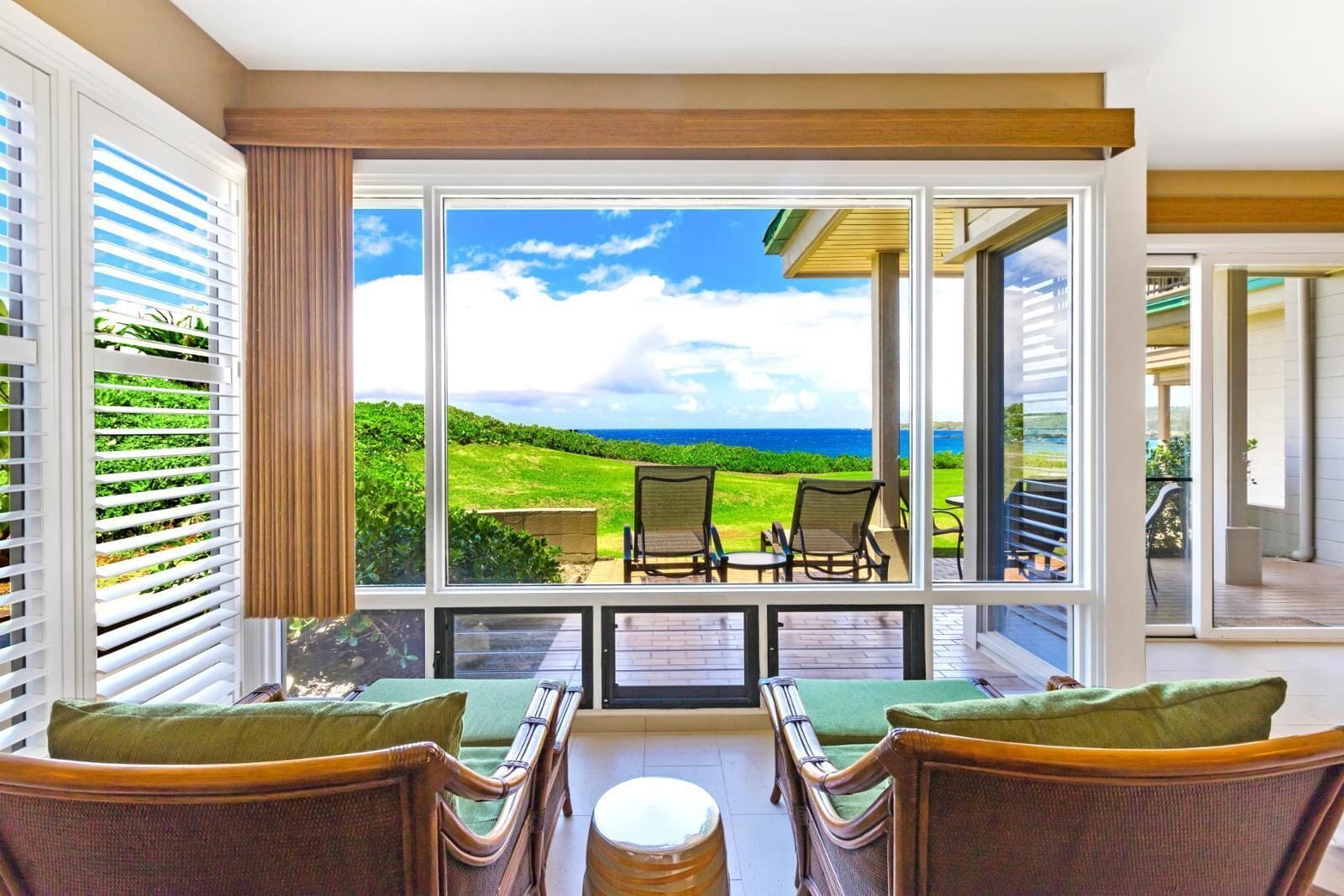 A balcony with wicker furniture and a view of a golf course.