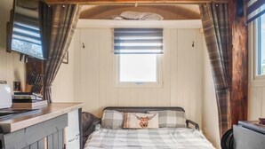 Um quarto aconchegante com uma cama, uma escrivaninha e uma janela com cortinas.