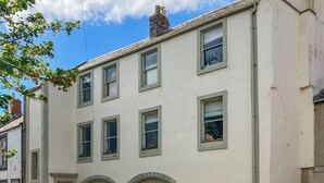 Un edificio con diverse finestre, un cartello con su scritto 'Campbell's Stables' e un'auto parcheggiata.