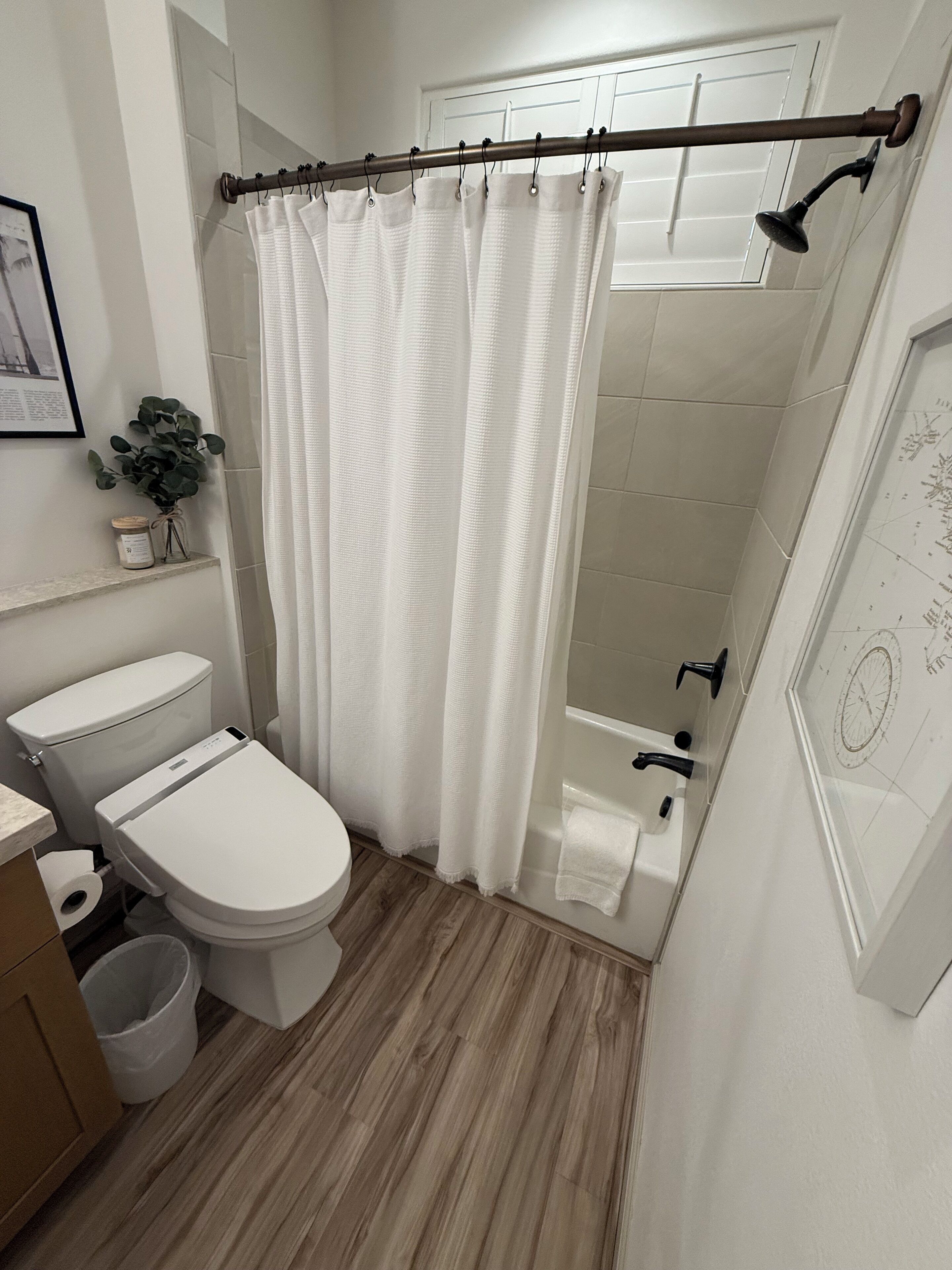 A modern bathroom with a shower, toilet, and sink.