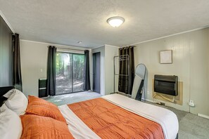 A hotel room with a bed, a window with curtains, a radiator, and a door leading to a balcony. - Accessible Home w/ Yard: 1 MI to Pere Marquette (Baldwin)