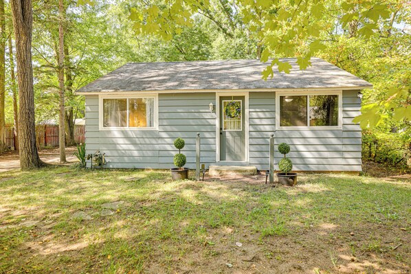 A small, single-story house with a front porch, two potted plants, and a wreath on the door. - Accessible Home w/ Yard: 1 MI to Pere Marquette (Baldwin)