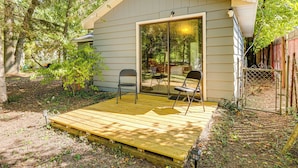 A small wooden deck with two chairs and a glass door leading to a covered area. - Fish, Hike, Golf! Accessible Baldwin Home w/ Yard (Baldwin)