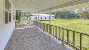 A wooden deck with a railing, a ladder, and a white building in the background. - 16 Mi to WEC: Horse-Friendly Home on 5 Acres! (Williston)