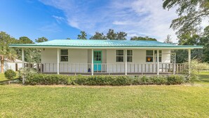 A single-story house with a green roof, a porch with a railing, and a small front yard. - 16 Mi to WEC: Horse-Friendly Home on 5 Acres! (Williston)