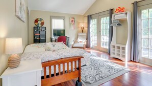 A bedroom with a bed, bedside table, lamp, and a desk with a chair. - Franklin Home w/ Deck, Creek Views: Walk to Shops (Franklin)