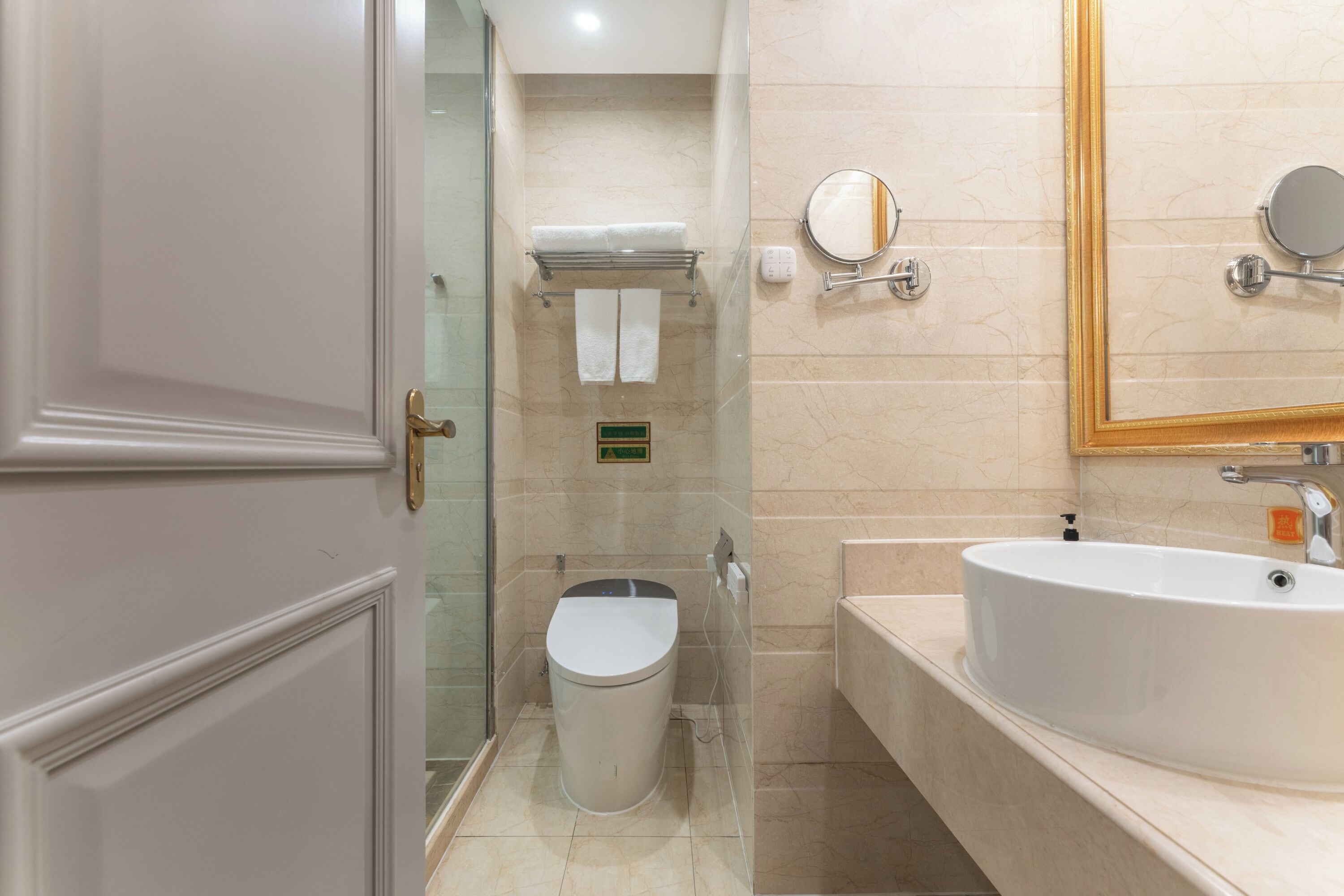 A modern bathroom with a toilet, sink, and mirror.