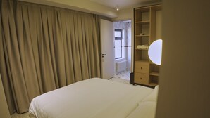 A bedroom with a large bed, a wardrobe, and a window with curtains. - Nomad Camp (Kaji-Say)