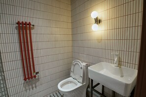 A bathroom with a toilet, a sink, and a towel rack. - Nomad Camp (Kaji-Say)