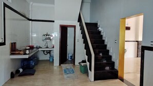 A spacious living area with a kitchen, a staircase, and a hallway leading to another room. - TCN Condo 168 (Phnom Penh)