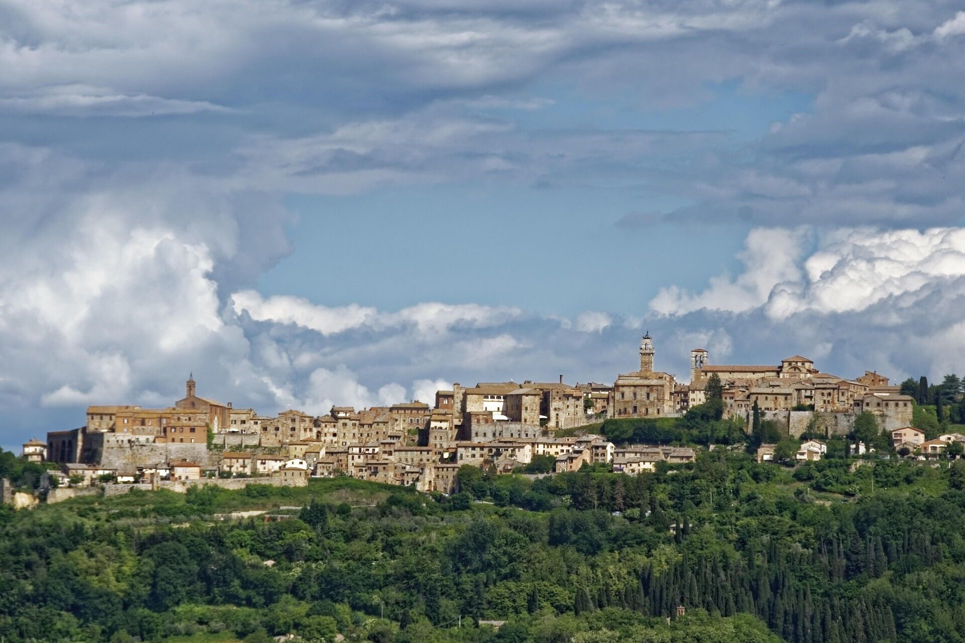 A historic town with ancient buildings, a prominent church, and a castle on a hill.