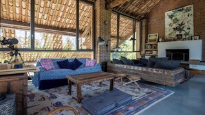 Amplia sala de estar con un ventanal, chimenea y estantería.