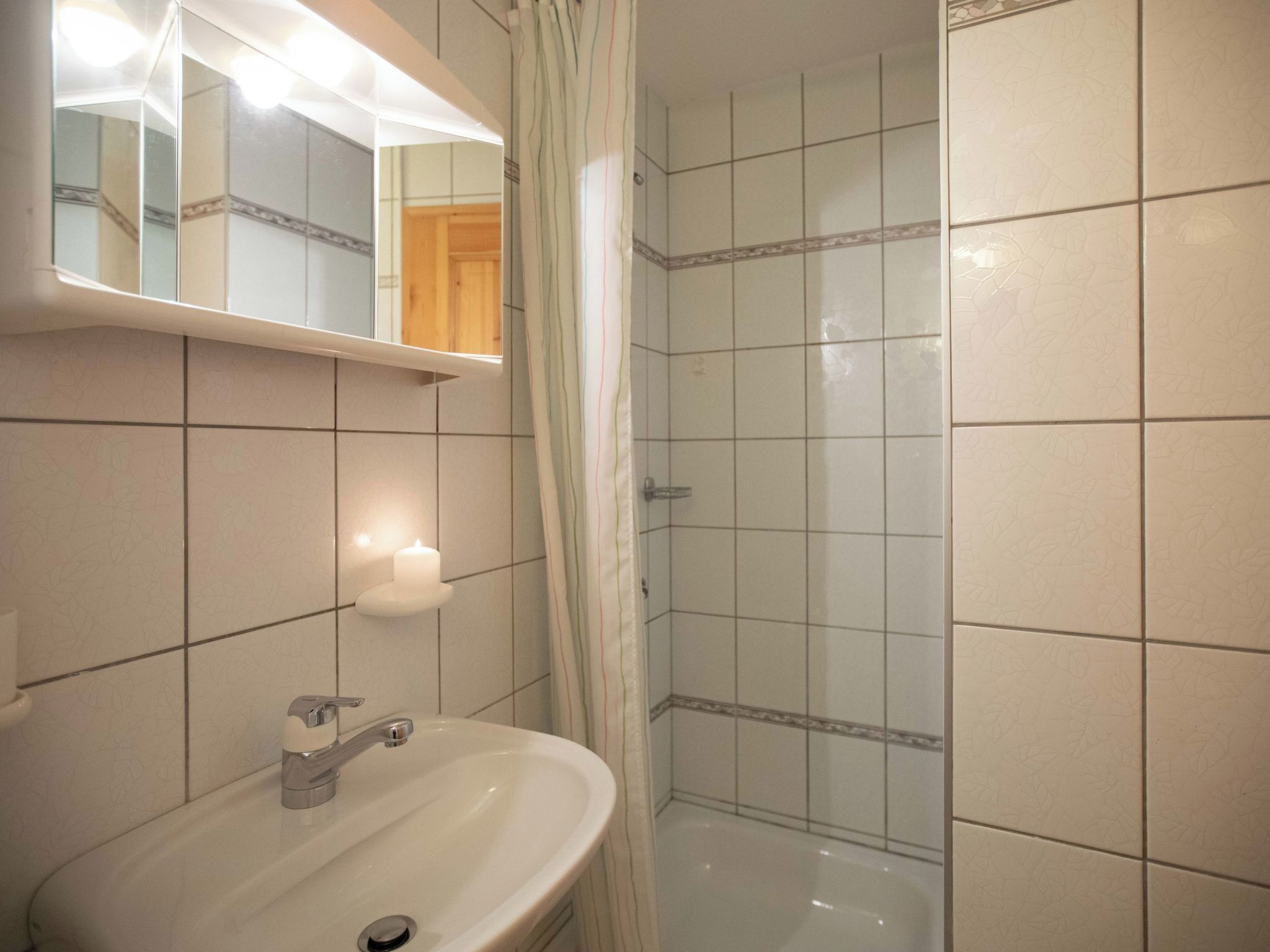 Une salle de bain avec un lavabo, un miroir et une douche.