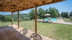 A wooden deck with a pool, lounge chairs, and a pergola. - Villa Torre With Pool And Ac (Poggibonsi)