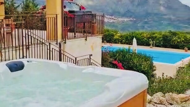 Un bain à remous avec vue sur la montagne et une piscine.