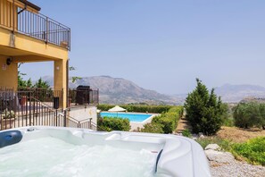 A hot tub with a mountain view, a swimming pool, and a balcony with a railing. - Sundrenched Sicilian Villa - Pool, Hot Tub, Gym, Sauna - Sleeps 10 Near Palermo (Ciminna Palermo)