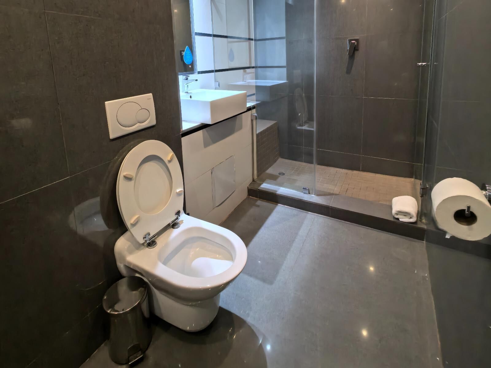 Moderni kylpyhuone, jossa on wc, suihku ja pesuallas.